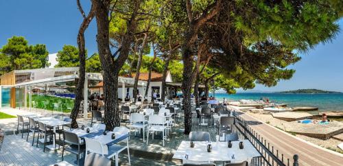 a restaurant with tables and chairs next to the water at Villas Arausana & Antonina in Vodice