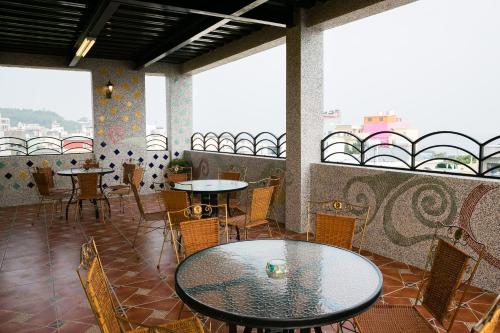 ein Esszimmer mit Tischen, Stühlen und Fenstern in der Unterkunft 采蝶法拉民宿 in Xiaoliuqiu