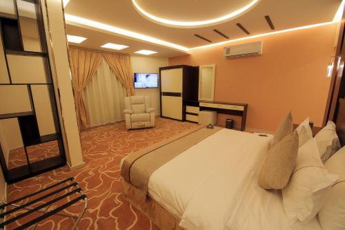 a hotel room with a large bed and a chair at فندق جولدن نايت Golden Night Hotel in Najran