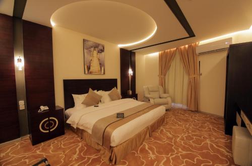 Habitación de hotel con cama y silla en Golden Night Hotel en Najrán