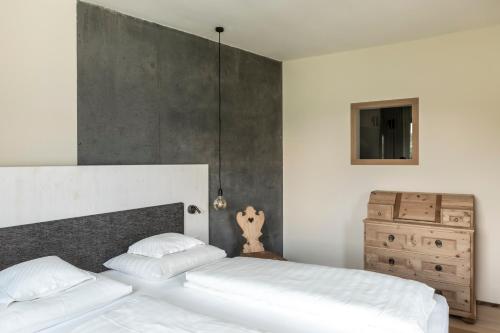 a bedroom with two white beds and a dresser at Boutique-Hotel Ballguthof am Golfplatz in Lana