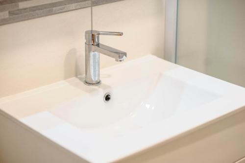 a white bathroom sink with a chrome faucet at Falcons Nest in Šibenik