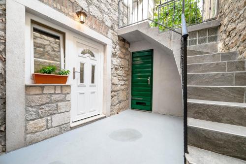 a green door in a stone building with stairs at Falcons Nest in Šibenik