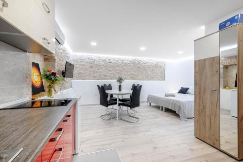 a kitchen and living room with a table and a bed at Falcons Nest in Šibenik