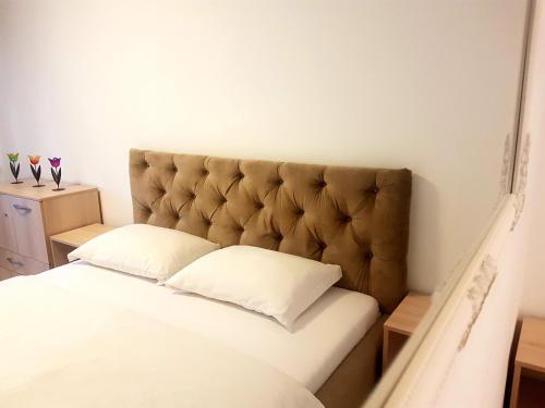 a bed with a padded headboard in a room at Cozy House Decebal in Cluj-Napoca