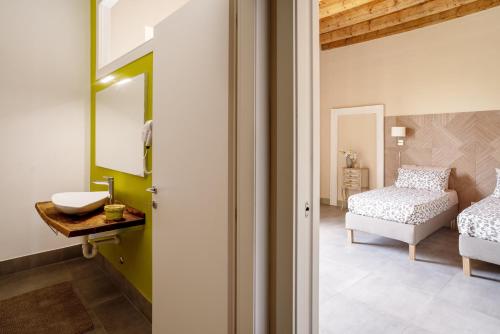 uma casa de banho com um lavatório e uma cama num quarto em B&B Dimora De Roteris em Dalmine