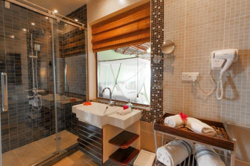 a bathroom with a sink and a shower at Villa Fleur De Lys in Makunduchi