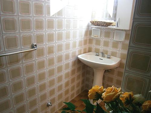 a bathroom with a sink and a mirror and yellow roses at Capri in Bibione