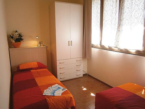 a bedroom with two beds and a cabinet and a window at Capri in Bibione