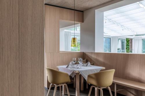 a dining room with a white table and chairs at Boutique-Hotel Ballguthof am Golfplatz in Lana