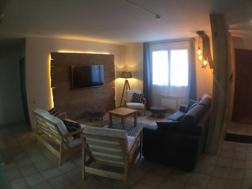 a living room with a couch and a tv at Domaine de la Loge in Flacey-en-Bresse