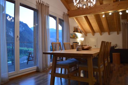 SuravaにあるFerienwohnung Albula im Herzen Graubündensのダイニングルーム(テーブル、椅子付)、大きな窓が備わります。