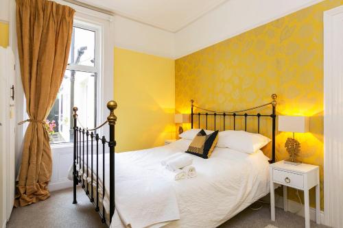 a bedroom with a bed and a yellow wall at Cyprus View Apartment in Belfast