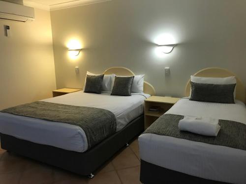 a hotel room with two beds in a room at Rocky Gardens Motor Inn Rockhampton in Rockhampton