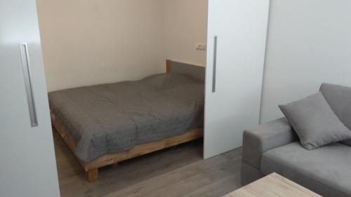 a small bedroom with a bed and a couch at Apt.Jana ,apt.Terezka in Stožec