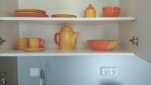 a shelf with cups and bowls on it at Apt.Jana ,apt.Terezka in Stožec