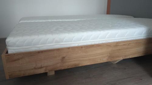a mattress on a wooden bed frame in a room at Apt.Jana ,apt.Terezka in Stožec