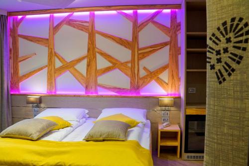 a bedroom with a bed with purple lights above it at Aktivhotel Santalucia in Nago-Torbole