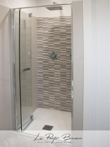 a shower with a glass door in a bathroom at La Porta Bianca in Trieste