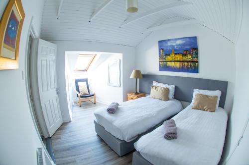 a bedroom with two beds and a chair in it at Liberty Townhouses in Dublin