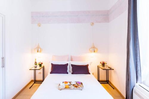 a bedroom with a white bed with two tables at Margana Tower in Rome