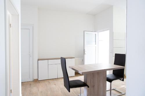 a dining room with a wooden table and two chairs at Holidayapartment Rüsselsheim in Rüsselsheim
