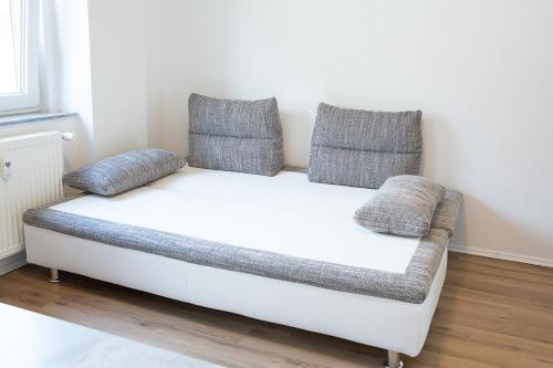 a white couch with two pillows on it in a room at Holidayapartment Rüsselsheim in Rüsselsheim