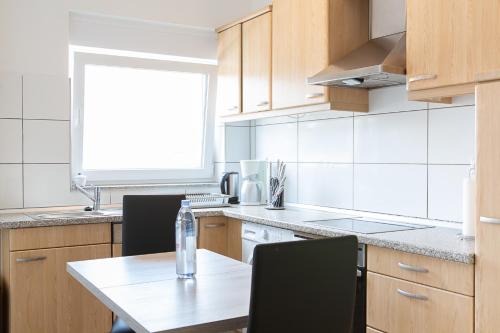 a kitchen with a table and chairs and a window at Holidayapartment Rüsselsheim in Rüsselsheim