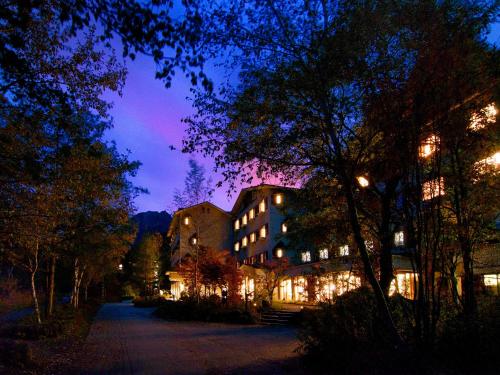 a building is lit up at night with lights at Kamikochi Lemeiesta Hotel in Matsumoto