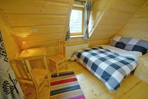 a bedroom with a bed in a log cabin at Willa Turnia in Kościelisko