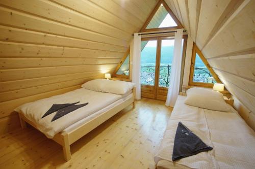 1 dormitorio con 2 camas en una cabaña de madera en Willa Turnia, en Kościelisko