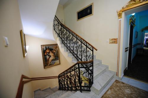 a staircase with a black wrought iron railing at Hotel Royal Craiova in Craiova