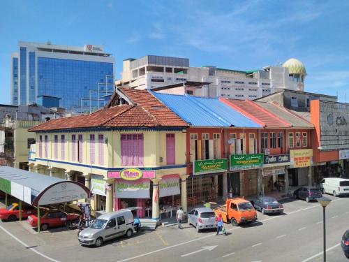 a city street with cars parked in front of a building at Classy Studio Apartment (KBCP) in Kota Bharu