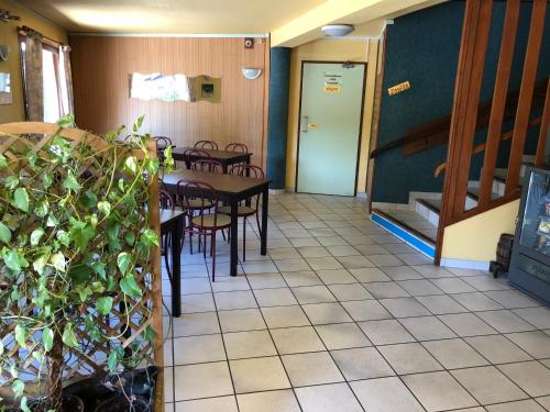 een eetkamer met een tafel en stoelen en een trap bij Symp'Hotel in Nivolas-Vermelle