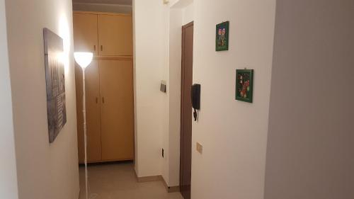 a hallway with a door and a light on a wall at La Vigna For Family in La Maddalena