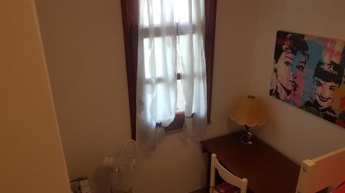 a room with a window with a desk at La Vigna For Family in La Maddalena