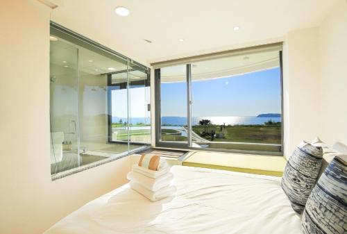 1 dormitorio con cama y ventana grande en Laguna Villas & Resorts, en Magong