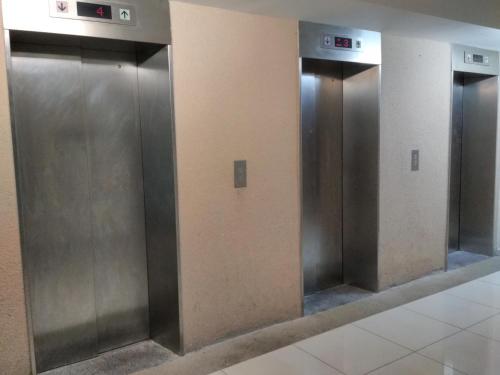 a row of silver elevators in a bathroom at Classy Studio Apartment (KBCP) in Kota Bharu