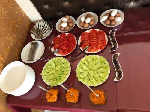 a table topped with plates and bowls of food at Hotel Living in Šuto Orizari