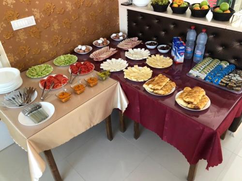 a table with a bunch of food on it at Hotel Living in Šuto Orizari