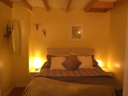 a bedroom with a large bed with two lamps at The Granary Country Retreat in Lampeter