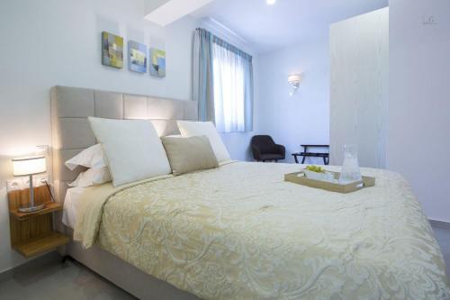a white bedroom with a large bed with white pillows at Villa Del Mar in Vasiliki