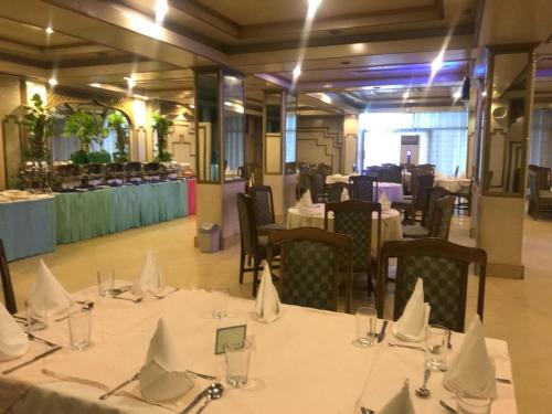 - une salle de banquet avec des tables, des chaises et des nappes blanches dans l'établissement Hotel Shalimar Rawalpindi, à Rawalpindi