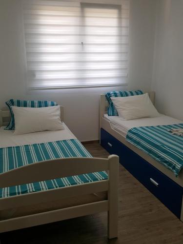 two twin beds in a room with a window at Apartments Sunny Hill in Tivat