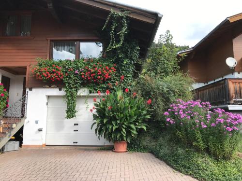 a white garage with a bunch of flowers on it at Haus Katharina in Wagrain