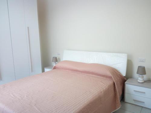 Dormitorio blanco con cama con manta rosa en nunzia casa vacanze, en Vietri