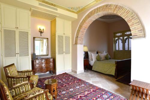 an archway in a bedroom with a bed and a chair at Palais Bayram in Tunis