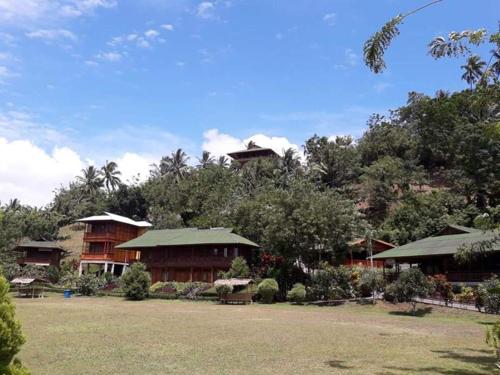 a group of houses on a hill with trees at Botanica Nature Resort in Bitung