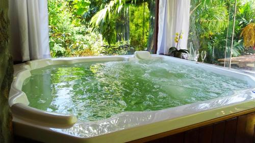 a bath tub filled with water in front of a window at Pousada Riacho Dos Cambucas in Abraão
