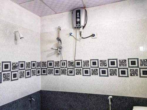 a bathroom with black and white tile on the wall at Kirinda Beach Front Hotel in Kirinda